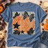 Orange polka-dot pumpkin DTF transfer with black-and-white polka-dot bow, black stars, and black maple leaves on a cream dot-textured background Shown on a Chambray t-shirt.