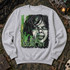 The Exorcist DTF transfer with grungy green and black distressed illustration of a demonic possessed face and a shadowy figure in a hat before a lit doorway Shown on a Ash crewneck sweatshirt.