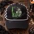 The Exorcist DTF transfer with grungy green and black distressed illustration of a demonic possessed face and a shadowy figure in a hat before a lit doorway Shown on a charcoal black front panel with white rope and black-and-white checkered mesh back trucker hat.