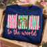 Joy to the World Christmas DTF transfer with a nativity scene inside the O, pink candy-cane stripe and teal checkered lettering, and pink script reading to the world Shown on a Indigo Blue crewneck sweatshirt.