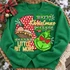 Maybe Christmas Perhaps DTF transfer with red polka-dot number one, nativity baby-in-a-manger scene, and lovestruck green Grinch face with heart-shaped eyes and snowflakes Shown on a Irish Green crewneck sweatshirt.