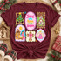 Jesus Is The Reason for the Season Christmas DTF transfer with nativity scene, Christmas tree, stained-glass church, cross, and angel panels in pastel sticker-sheet style Shown on a Wine t-shirt.