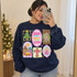 Jesus Is The Reason for the Season Christmas DTF transfer with nativity scene, Christmas tree, stained-glass church, cross, and angel panels in pastel sticker-sheet style Shown on a Navy crewneck sweatshirt.