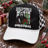 Have Yourself a Scary Little Christmas DTF transfer with Ghostface-style killer holding a knife and wrapped present at a snowy window with Christmas tree Shown on a black foam front, white bill, black-and-white checkered mesh back trucker hat.