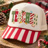 Frosted cookie-style TEACHER lettering DTF transfer with leopard print, Christmas trees, candy stripes and checkerboard patterns, surrounded by a candy cane, holly, paint palette, pencil, ruler and book icons Shown on a cream front panel with red-and-white striped bill and cream mesh back trucker hat.
