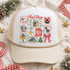 True Story nativity DTF transfer with hand-drawn sticker-sheet grid featuring the holy family, sheep, donkey, church, angel, manger, star of Bethlehem, cross, empty tomb, Christmas tree, and polka-dot bow framed by scribbly borders and snowflakes Shown on a white foam front, tan rope, cream mesh back trucker hat.