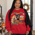 Vintage carnival-style Halloween DTF transfer with grinning black cat, top-hatted jack-o'-lantern, striped circus tent, bunting, and Enter Step Right Up signpost Shown on a Cherry Red crewneck sweatshirt.