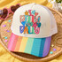 I Dilly and Dally DTF transfer in rainbow bubble lettering with hand-doodled stars and hearts in pastel and bright colors Shown on a ivory front panel, rainbow striped bill, white mesh back trucker hat.
