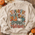 Thankful Grateful Blessed DTF transfer with hand-drawn orange, cream, and teal pumpkin trio, plaid bow, autumn leaves, and berries Shown on a Sand crewneck sweatshirt.