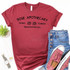Schitt's Creek Rose Apothecary Screen Print Heat Transfer, red T-shirt with black text and logo design, paired with blue denim shorts, pink Converse sneakers, and a wristwatch, on a white background.