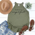 Perfectly Imperfect Screen Print Transfer, olive green sleeveless top with black script text, accompanied by a tan wide-brim hat, distressed denim shorts, brown sandals, and a small bouquet of green plants.