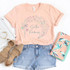 Scatter Kindness Heart Screen Print Heat Transfer, peach T-shirt with colorful heart and dandelion design.