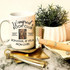 Winifred's Book Club Hocus Pocus Sanderson Sisters Sublimation Transfer, featuring a white coffee mug with black text and an image, along with decorative items including a plant, a gold keychain, and a makeup spray bottle.