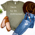 Dare to Be Different Screen Print Heat Transfer, olive green T-shirt with white text, paired with distressed blue jeans, brown shoes, a brown hat, and a watch, laid out on a flat surface with a small potted plant.