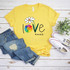 Love One Another Daisy FINAL STOCK Screen Print Heat Transfer T-shirt, yellow casual T-shirt with colorful floral love design and hashtag, laid out with denim jeans, white sneakers, and green plant for display.