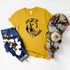 Just The Tip Screen Print Transfer, yellow T-shirt with black graphic design and text, jeans, plaid scarf, and cotton branch accessories displayed on a white background.