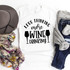 Less Thinking More Wine Drinking sublimation transfer on a white T-shirt, with additional accessories like a hat, scarf, jeans, and socks arranged around it.