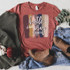 Hustle Hard Pray Harder Screen Print Heat Transfer, a graphic design on a maroon T-shirt with colorful brush strokes and stylish text.