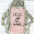 I Don't Cook I Don't Clean FINAL STOCK Screen Print Heat Transfer T-shirt, pink T-shirt with humorous ring quote and illustration, laid on a white wooden background with a khaki hoodie partially covering it.