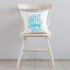 Let It Snow Somewhere Else Sublimation Transfer, white decorative pillow with blue winter-themed text and snowflake designs on a white chair.
