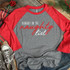 Probably On The Naughty List WHITE/RED Screen Print Transfer Christmas-themed T-shirt on wooden background with festive decorations.