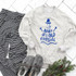 Baby It's Cold Outside Snowman Screen Print Heat Transfer, image of a sweatshirt with a snowman graphic and the phrase 'Baby it's cold outside', paired with striped pajama pants, slippers, and a small pine branch with red berries.