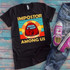 Impostor Among Us Adult Final Stock Screen Print Heat Transfer T-shirt, featuring a colorful Among Us character with a finger to lips, on a black T-shirt laid on a wooden surface with jeans and pink sneakers.