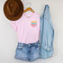 Sandy Salty Happy Can Hugger Screen Print Heat Transfer, colorful graphic design on a pink T-shirt, displayed with a brown hat, denim shorts, and a light blue denim shirt.