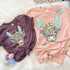 Shaggy Cow Easter YOUTH Screen Print Heat Transfer, colorful cartoon distressed dogs' face with bunny ears, bow, and carrot print on pastel pink and purple t-shirts for Easter holiday.