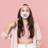 Floating On The River POCKET Screen Print Heat Transfer, a woman wearing a pink face mask with a colorful river design and text, pointing at her mask against a pink background.