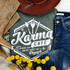 Karma Cafe Screen Print Heat Transfer, white graphic design with text and utensils on dark fabric, surrounded by fashion accessories and yellow decorative flowers.