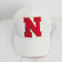Red with Gold Glitter Chenille Letters, white baseball cap with a red letter 'N' applique edged with gold glitter, on a soft textured surface.