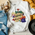 Legends Never Die DTF Transfer, illustrated graphic design of three women in colorful outfits with the text 'Legends Never Die' on a white sweatshirt.