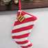 Custom Initial TAN Leather Patch Christmas Stocking, red and white striped Christmas stocking with a leather initial patch hanging from a pink knitted loop.