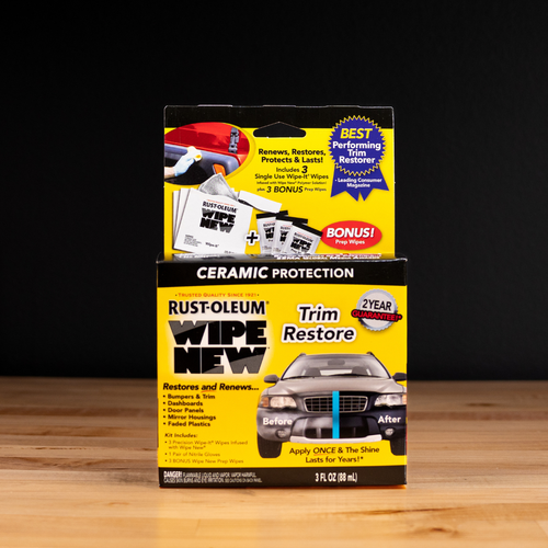 Product packaging of Rust-Oleum Wipe New Trim Restore with ceramic protection and 2-year guarantee, displayed on wood surface