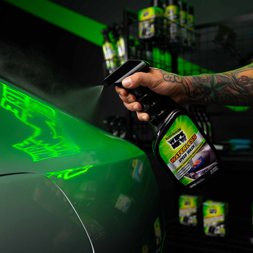 Tattooed person spraying Rust-Oleum Wipe New Waterless Speed Wash onto green car panel for cleaning and shine