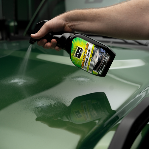 Spraying Wipe New Ceramic Boost Hybrid Sealant on green car hood for enhanced gloss and hydrophobic protection
