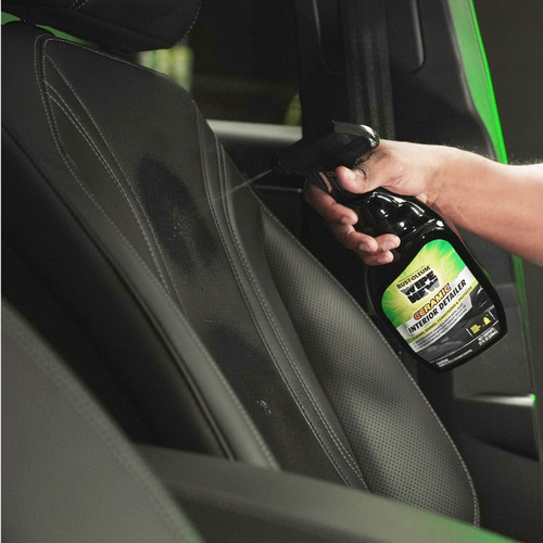 A hand spraying a bottle of Rust-Oleum ceramic interior detailer on a car seat.