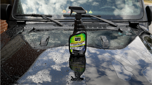 A bottle of Rust-Oleum Ceramic Boost Hybrid Sealant on a wet black car hood with reflections and water droplets.