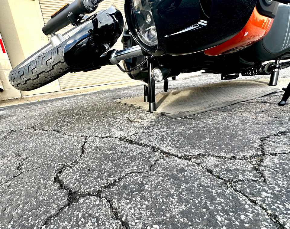 Protective Delrin shock slider keeping Harley Nightster elevated during fall
