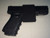 This photo shows the optional/additional retention strap on a large frame Glock-23 for mounting the FAST Holster in a vehicle to make the firearm more secure.