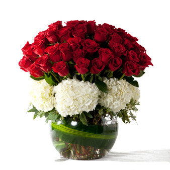 In My Heart is a classic luxury romance , clean, bright an giftable. Red roses are cluster in a dome with white hydrangeas at the base in a round green glass bowl vase hand crafted by Lexis Florist Houston.