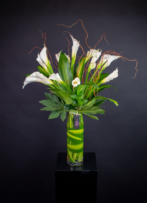 All white Calla Lily arrangement in clear glass vase.