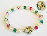 7" Christmas stretch bracelet with enameled nativity medal. 8mm imitation round pearl beads with a 6 mm red and greeen multi faceted aurora borealis finished crystal beads. Comes with  a gold stamped holy prayer card included.