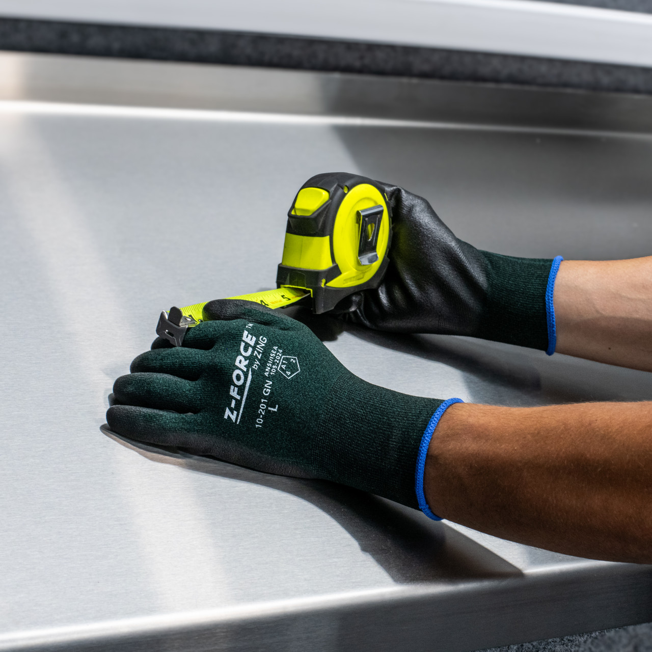 Safety worker measuring while wearing his Z-Force General Purpose Glove, 18 Gauge Green Bio-base Nylon+Spandex liner, Nitrile palm coated, Touchscreen (10-201 GN 