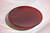 18.5" diameter fused art glass that has a mix of transparent deep red with streaks of opaque white. Best near bright light or backlit. Shown lying down.