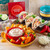 Tastefully Simple Dips to Dinner™ gift box and Fiesta Party Seasoning™ displayed with tacos, creamy dip, tortilla chips, mini sweet peppers, and shredded cheese.