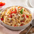 Bowl of Pasta with chicken and red peppers.