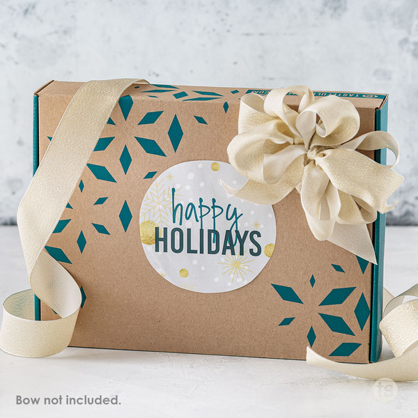 Tastefully Simple gift box with a "Happy Holidays" gift tag and decorative ribbon.