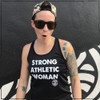 This is the front view of the Strong Athletic Woman Black Performance Racerback Wicking Tank Black with White Ink by Strong Athletic. The words on this black tank are printed in white ink. The Strong Athletic logo is printed on both the front and the back of the tank. This shirt is made by Strong Athletic the company that supports women, girls and the LGBTQIA2S+ community in sports and athletic. Strong Athletic made the Strong Athletic Woman design because we want to amplify the voices of all the strong women in the world, working to make a difference for girls and women in sports. 